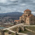 Aerial view of Jvari Monastery, a World Heritage Site in Mtskheta, Georgia, showcasing religious and architectural heritage.