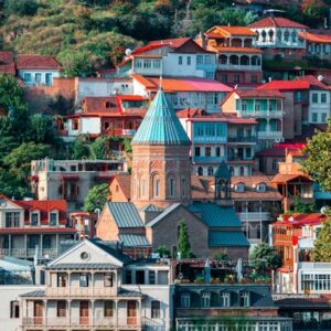 Vibrant view of Tbilisi's historic architecture with colorful houses and lush greenery.