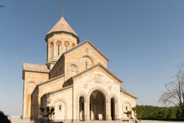 A beautiful historic stone church stands under a clear blue sky, representing architectural elegance.